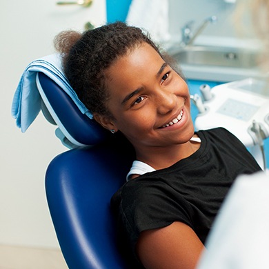 Smiling young woman in dental chair
