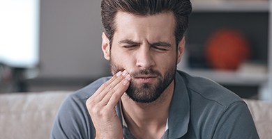 Man holding jaw in pain