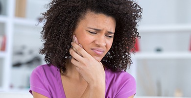 Woman holding jaw in pain